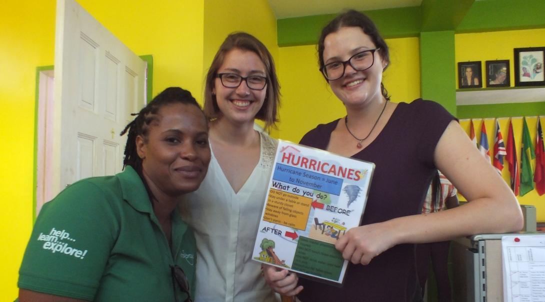 Female Projects Abroad Disaster Managment interns pose with a poster about dealing with hurricanes during Disaster Management work experience in Jamaica. Female International Development interns pose in a day centre holding a poster during their Disaster Management work experience in Jamaica.